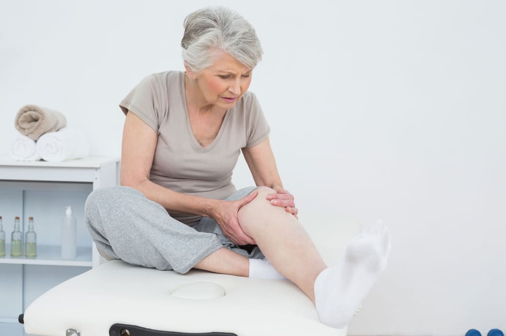 Eine Ältere Dame mit Schmerzen im Knie