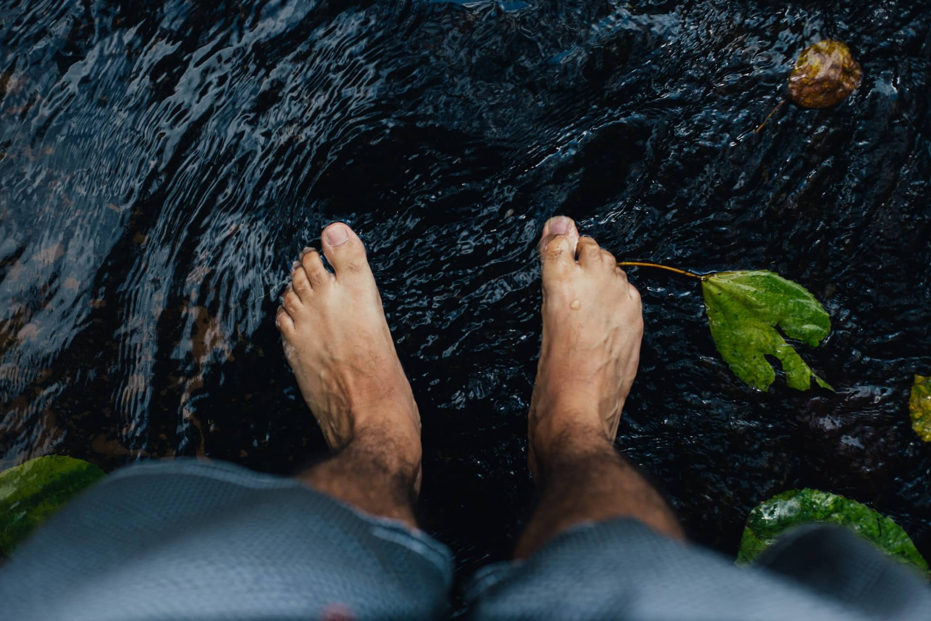 Füße die in in der Natur in Wasser gehalten werden